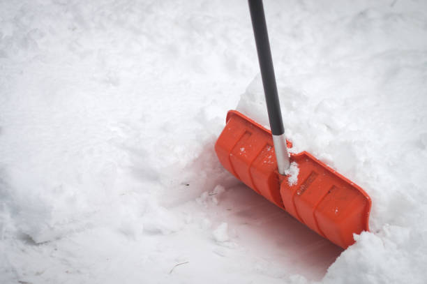 istock Snow shovel in bright orange color in snow 654655328