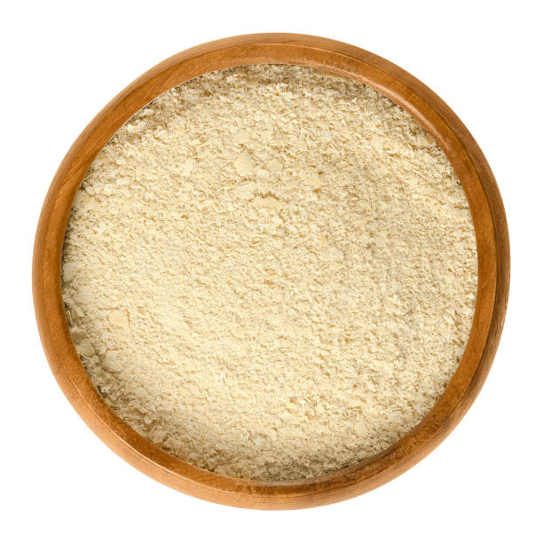 istock Nutritional yeast flakes in wooden bowl over white 654668580