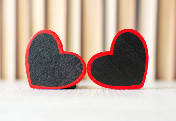 istock Two heart shapes in front of books 654683628