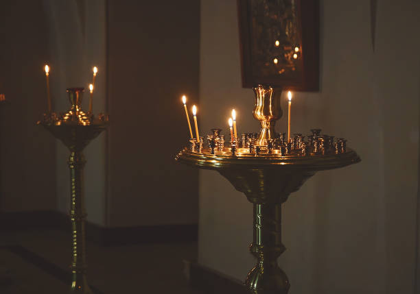 istock lighting candles in a church 654685904