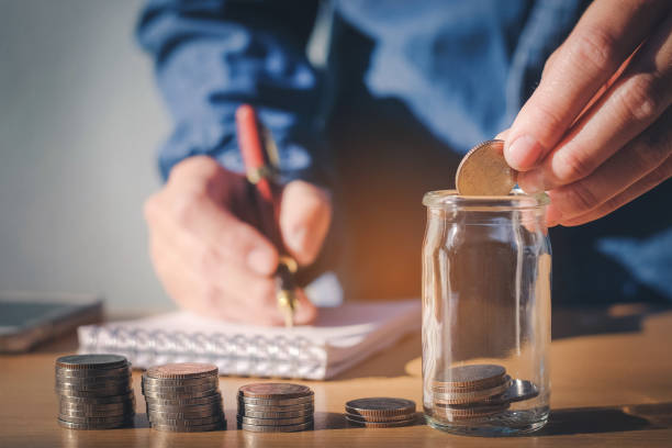 istock Saving money concept Man hand putting Row and coin Write Finance 654685944