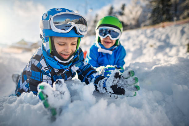 istock Two little boys in ski outfits playing in snow 654694452