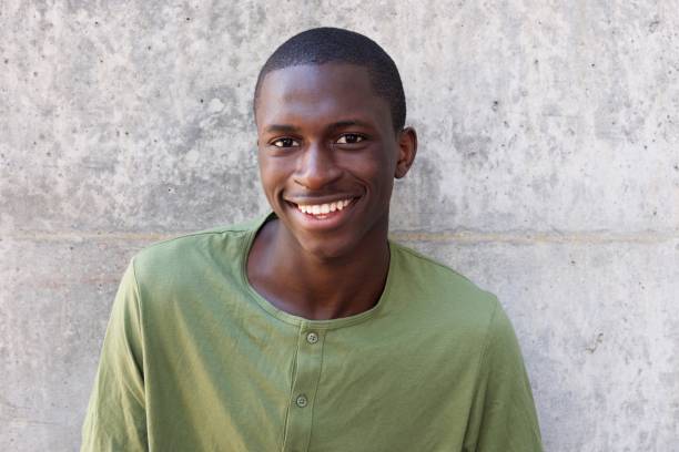 istock Cheerful young african man standing against wall 654703784