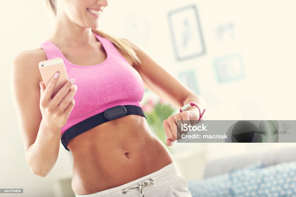 Sports woman using smart watch and checking her heart rate Picture showing sports woman using smart watch and checking her heart rate Adult Stock Photo