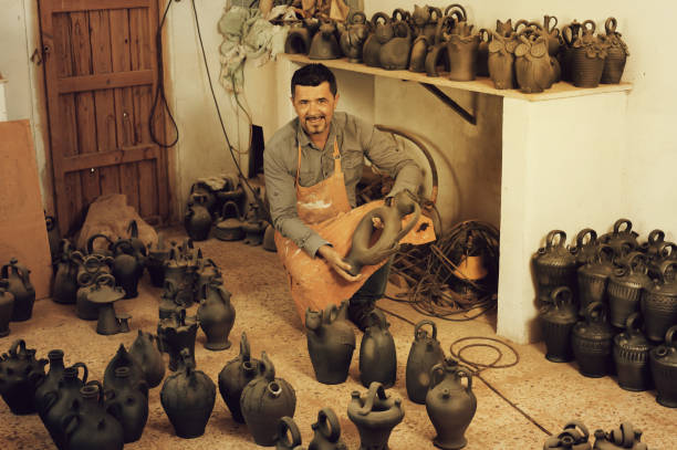 istock Cheerful male artisan with ceramic vases 654716000