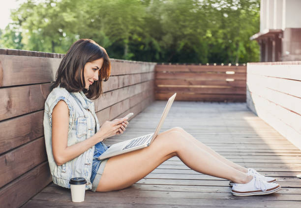 istock Trendy student girl using laptop outdoors 654721426