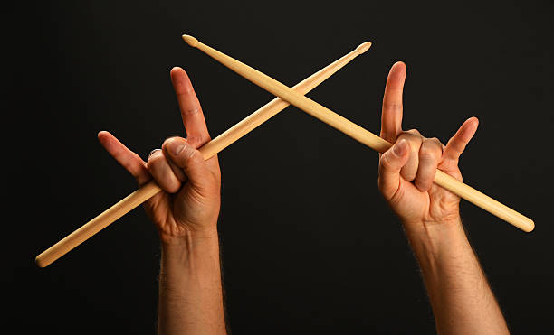 Cropped Hands With Rock Sign Holding Drumsticks Against Black Background  drummer hands stock pictures, royalty-free photos & images