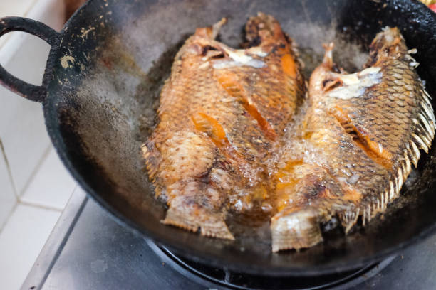 istock Fried tilapia fish in a frying pan with hot oil 654727126