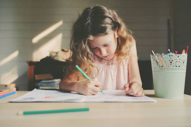 istock child girl drawing at home with colored pencils 654729470