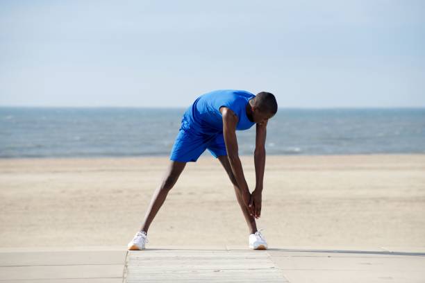 istock Young african american man stretching on the beach 654729964