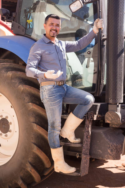 istock Farmer near large wheels tractor 654737338