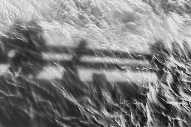 Minimalist black and white image of shadows reflecting in waters below a pier on the Columbia River Gorge