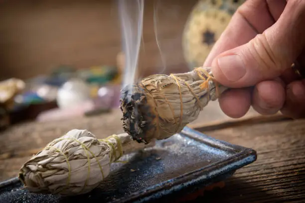 Photo of Man burning white sage incense