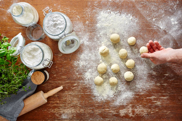 istock hand rolling out dough little pieces of dough on wooden kitchen workspace 654747344