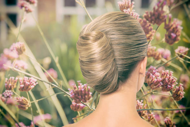 Woman beautiful banana chignon and pink flowers Woman beautiful banana chignon and pink flowers bridal hair stock pictures, royalty-free photos & images