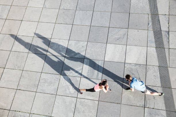 istock young female and male stretching, elevated view 654748446
