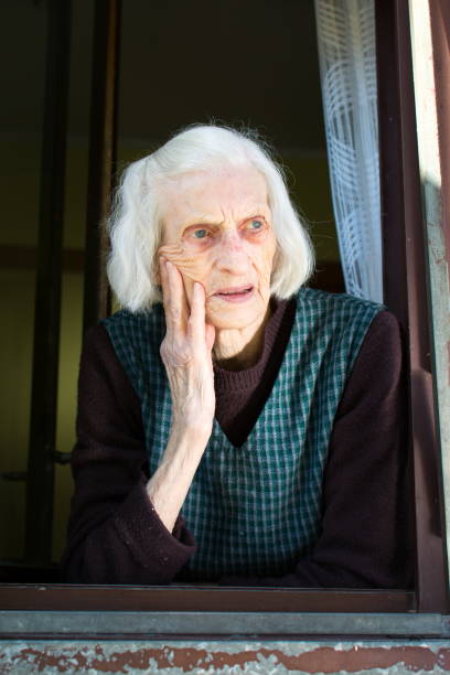 istock Senior woman on the house window 654760448