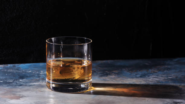 istock Glass of whiskey with ice on the table 654761458