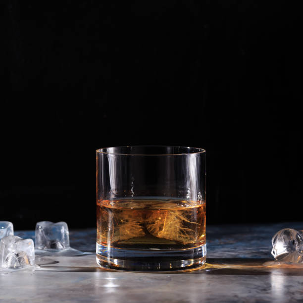 istock Glass of whiskey with ice on the table 654761460