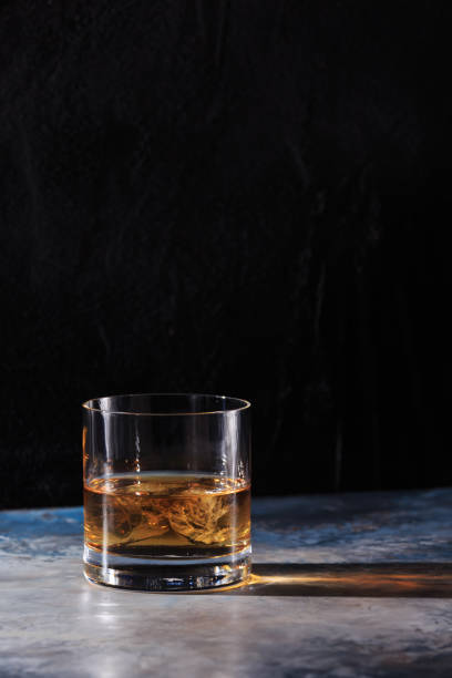 istock Glass of whiskey with ice on the table 654761470