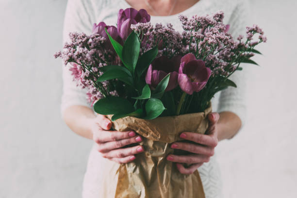 blumenstrauß von frühlingstupfeln blumen in geschenkpapier eingewickelt - tulip bouquet stock-fotos und bilder