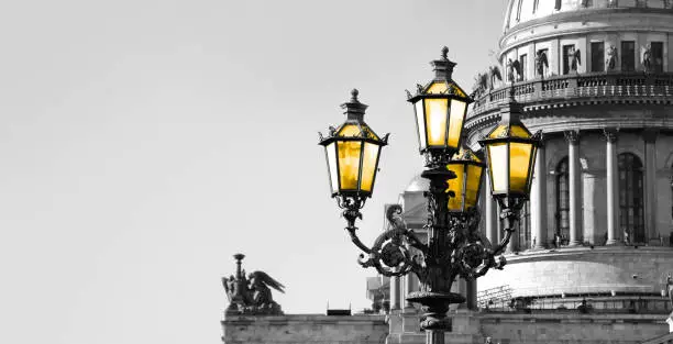 Black and white view of Saint Isaac Cathedral in Saint Petersburg with color vintage street lamp with yellow light