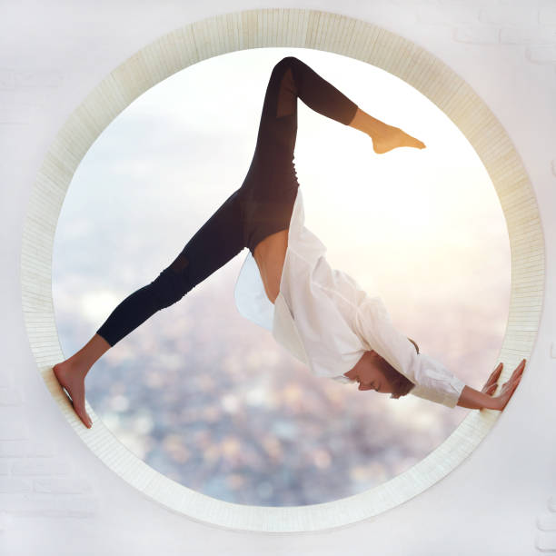 Young woman doing yoga Young woman doing yoga in the round window yoga pants photos stock pictures, royalty-free photos & images
