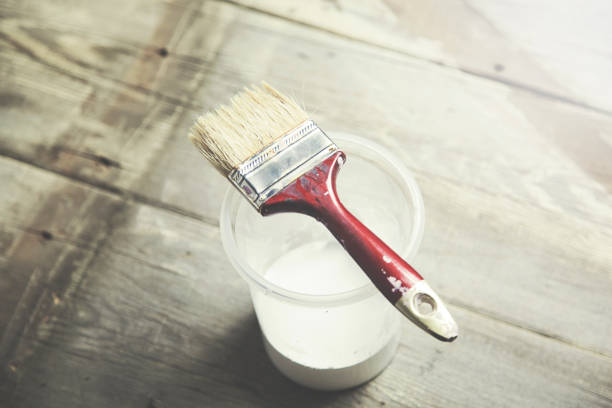 istock paint brush on can lying on wooden table 654782308