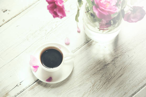 istock Pink roses and coffe on the wooden table 654784806