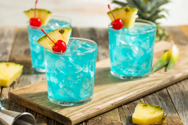 Refreshing Blue Hawaii Cocktail Punch Refreshing Blue Hawaii Cocktail Punch with Pineapple and Cherry punch drink stock pictures, royalty-free photos & images