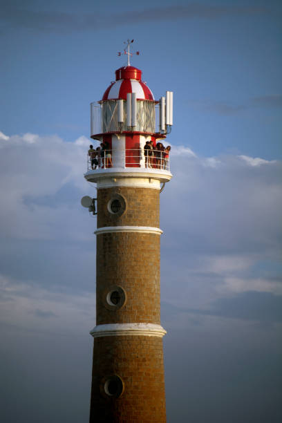 Cape Polonio lighthouse seen against blue sky In the image are seen some visitors at the top of the Lighthouse of Cape Polonio, uruguay. cabo polonio photos stock pictures, royalty-free photos & images