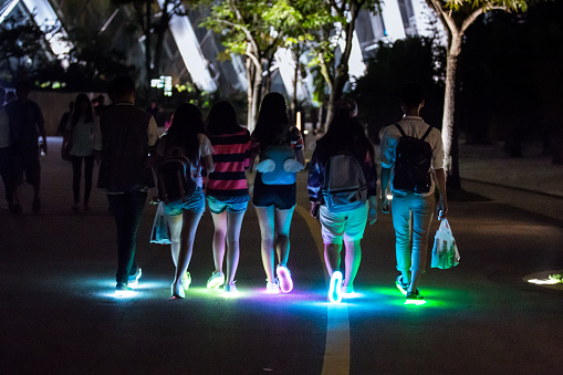 Teenagers wearing light up shoes at night at the Gardens By The Bay, in Singapore.