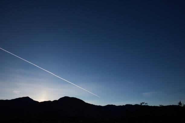 Contrail After Sunset, Anza Borrego State Park, California Contrail from jet marks twilight sky, mountains in silhouette. Anza Borrego State Park, California. borrego springs photos stock pictures, royalty-free photos & images