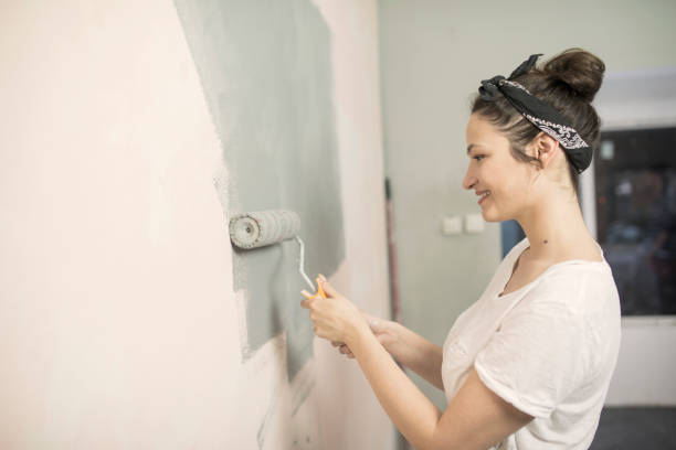 istock Woman painting wall 654805928