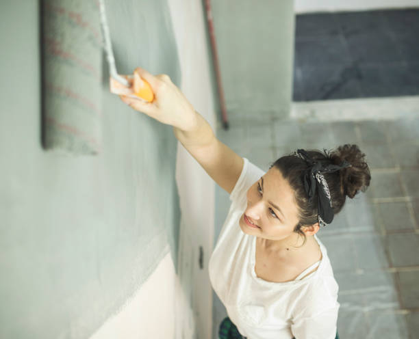istock Woman painting wall 654805998