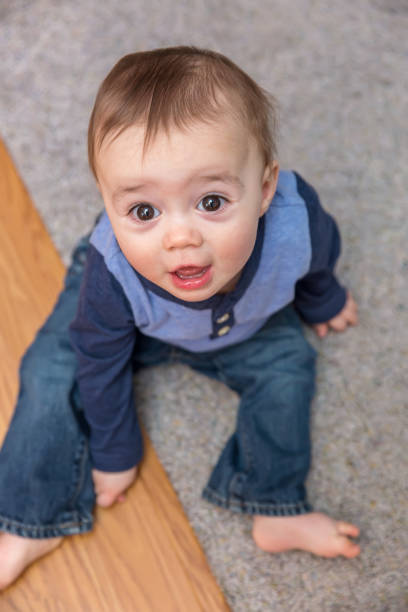 istock Baby Boy Sitting On Floor Looking Up 654809292