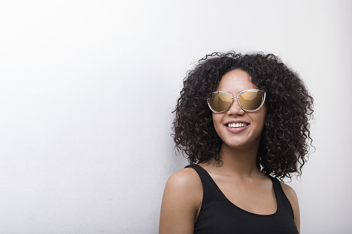 Stylish African American female model wearing sunglasses