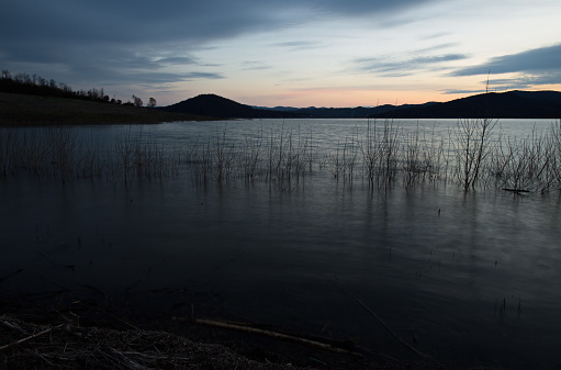 Beautiful image of a lake at dusk, with soft colors and dark shadows