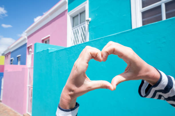 Heart shape against Bo Kaap houses Woman's hands making a heart shape finger frame in Bo Kaap, Cape Town, South Africa. malay quarter photos stock pictures, royalty-free photos & images