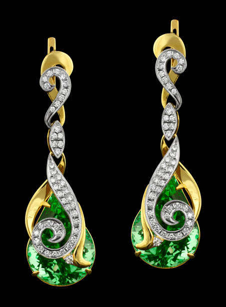 istock Golden earrings with diamonds and green gem isolated on black 654813036