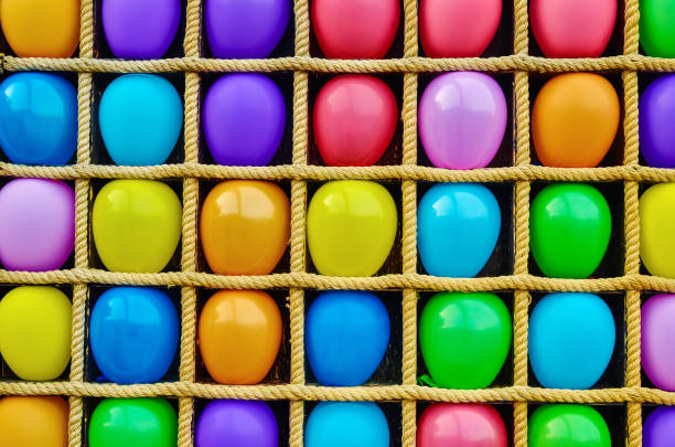 stand en bois avec la corde colorée et les ballons. fond abstrait multicolore coloré de ballon. amusement jetant des fléchettes aux ballons. - rubber dart photos et images de collection