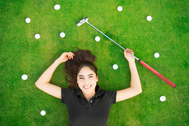 istock Young Hispanic Women Laying On The Putting Green 654830140