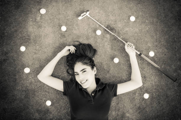 Young Hispanic Women Laying On The Putting Green