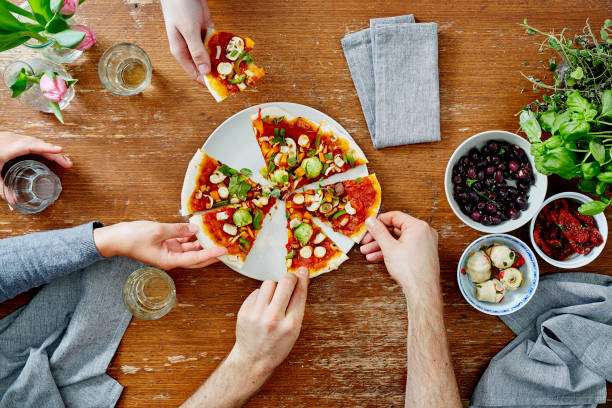 istock three people sharing organic delicious pizza at dinner party 654840184