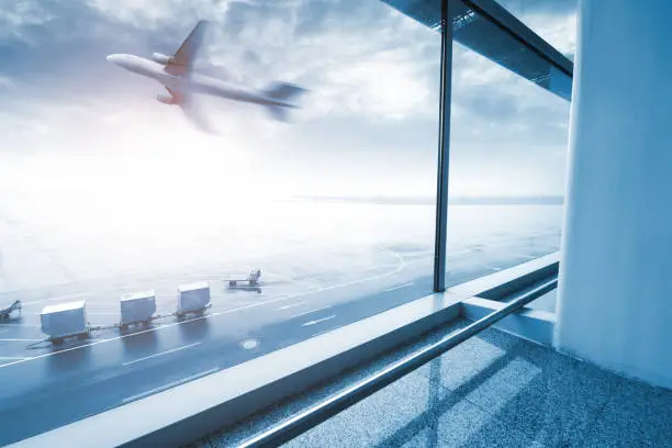 Photo of modern airport scene of passenger motion blur with window outside.