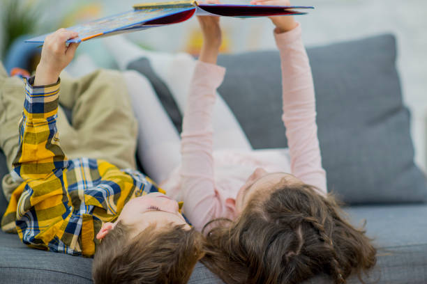 istock Looking at a Book on the Couch 654895874