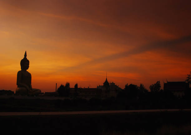 Silhouette of Big Buddha statue on sun set with foreground big fishing net tools.