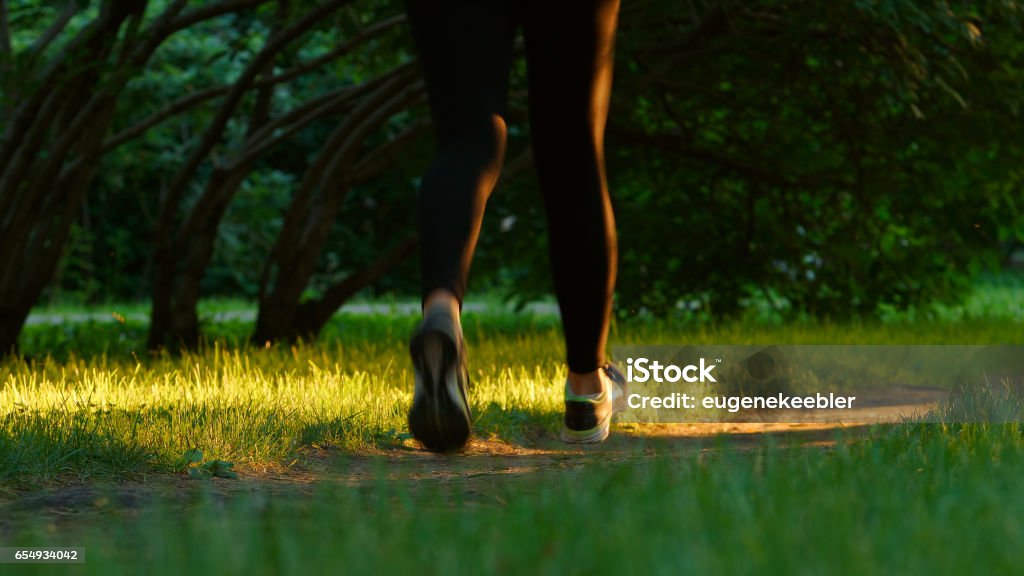 Mujer joven corre en un sendero - pies nivel - Foto de stock de Adulto libre de derechos