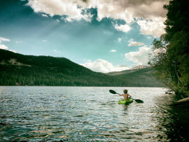 istock Child Kayaking alone on a big mountain lake 654939362