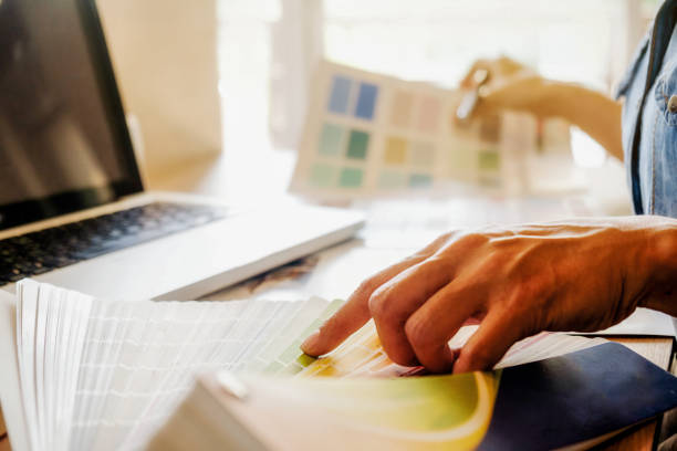 istock Graphic design and color swatches and pens on a desk. Architectural drawing with work tools and accessories. 654939384